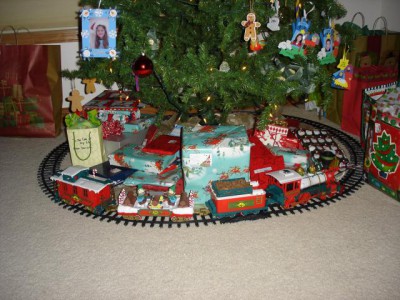Поезд вокруг елки.<br />На елке маленькие детские фотографии в самодельных рамочках.