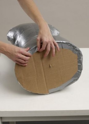 Вырезать овал из многослойного картона и закрепить его в месте соединения с торсом.